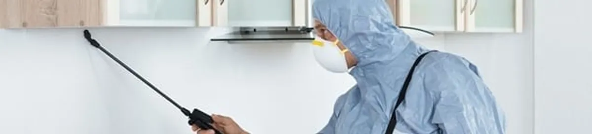 Termite treatment technician applying indoor pest control spray in Honolulu, HI