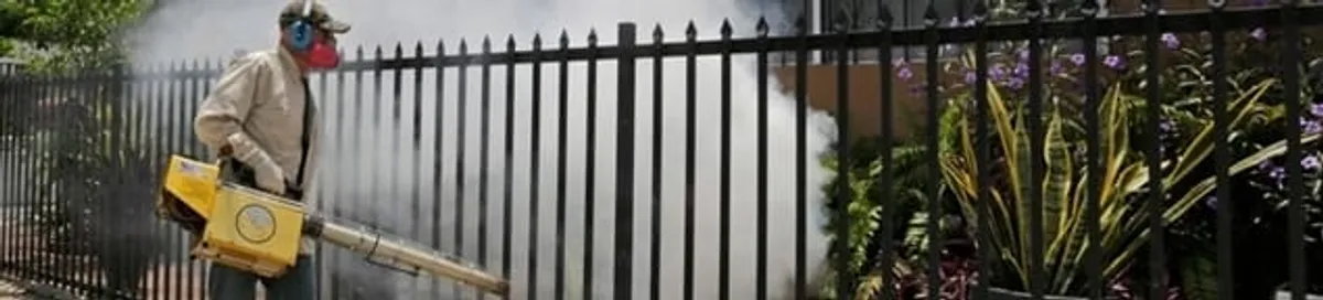Mosquito control technician fogging a yard perimeter for mosquito reduction in Honolulu, HI